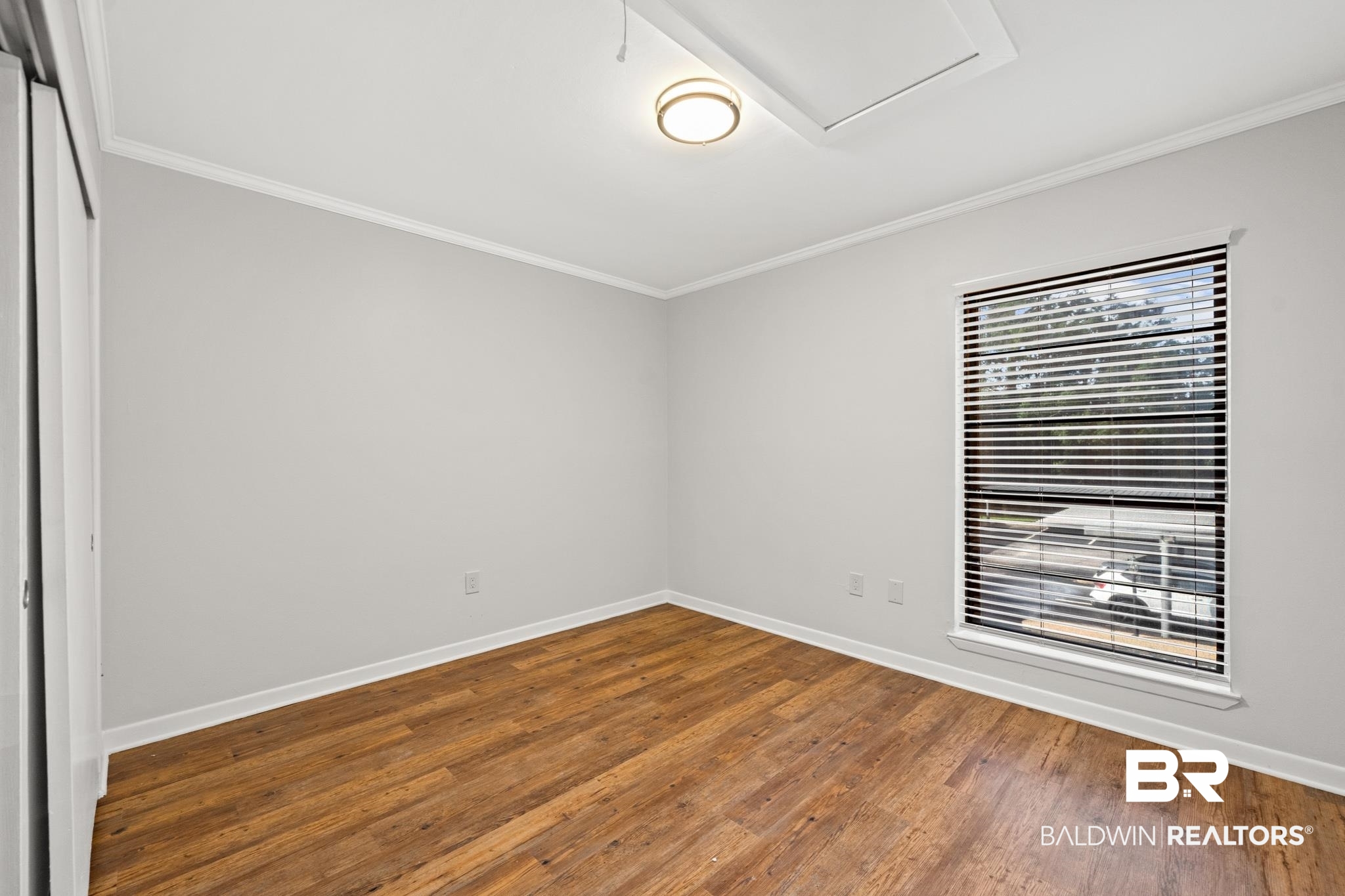 2901 Grant Street, Unit 802 Mobile, AL 36606 - Photo 23 of 37 Spare room featuring wood-type flooring and ornamental molding