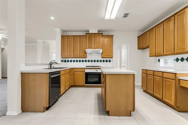 a kitchen with stainless steel appliances a stove sink and cabinets