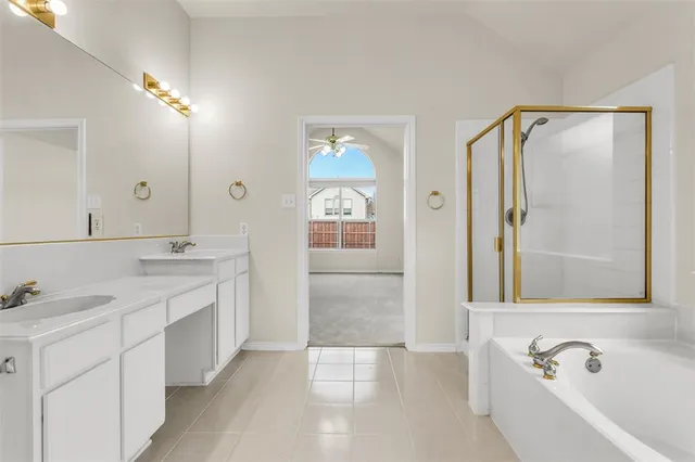 a spacious bathroom with a tub sink and mirror