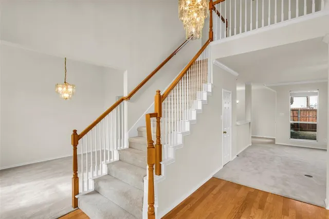 a view of an entryway with wooden floor leading to a furnished livingroom and windows