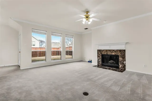 an empty room with windows and fireplace