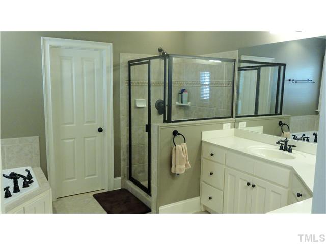 3706 Congeniality Way Raleigh, NC 27613 - Photo 7 of 10 a bathroom with a sink a mirror and shower