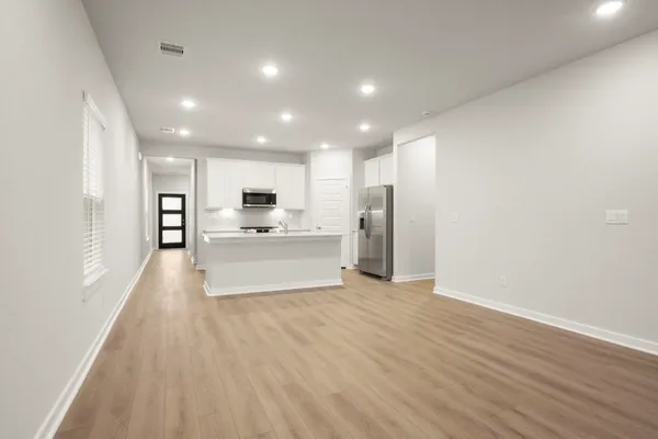 a view of a kitchen with a sink and dishwasher a refrigerator with wooden floor
