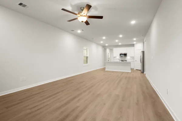 a view of an empty room with a kitchen