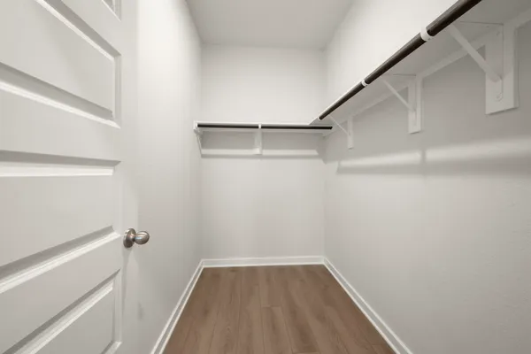 a view of walk in closet with empty racks