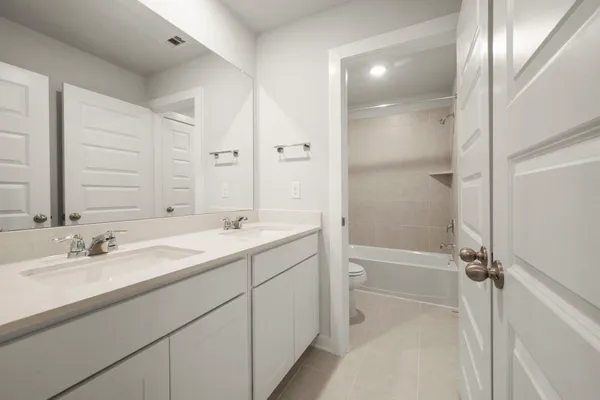 a bathroom with a double vanity sink toilet mirror and shower