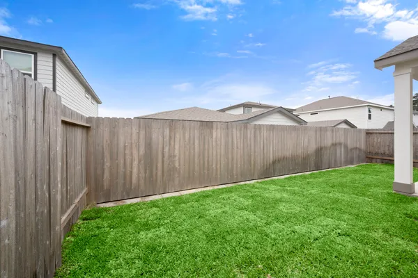 a view of a backyard with wooden fence