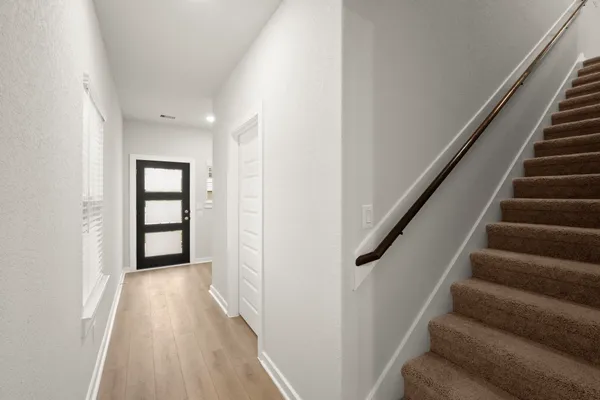 a view of a hallway with wooden floor and entryway