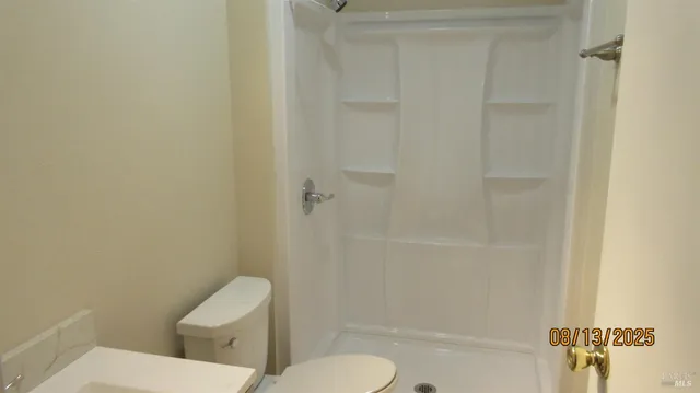 a white toilet sitting next to a bath tub