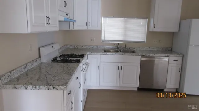 a kitchen with granite countertop cabinets stainless steel appliances and a counter space