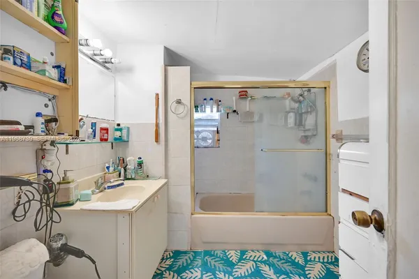 a bathroom with a sink a mirror a bathtub and shower