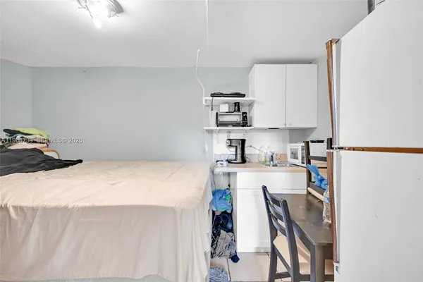 a kitchen with a table chairs refrigerator and cabinets
