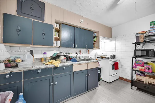a kitchen that has a lot of cabinets and wooden floor