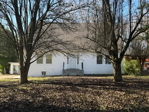 a white house that has a tree in front of it