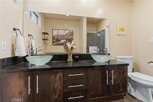a bathroom with a granite countertop sink a toilet and mirror