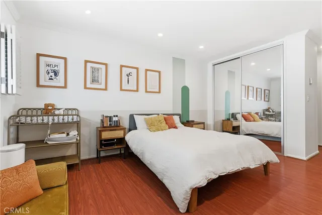 a bedroom with a bed and wooden floor