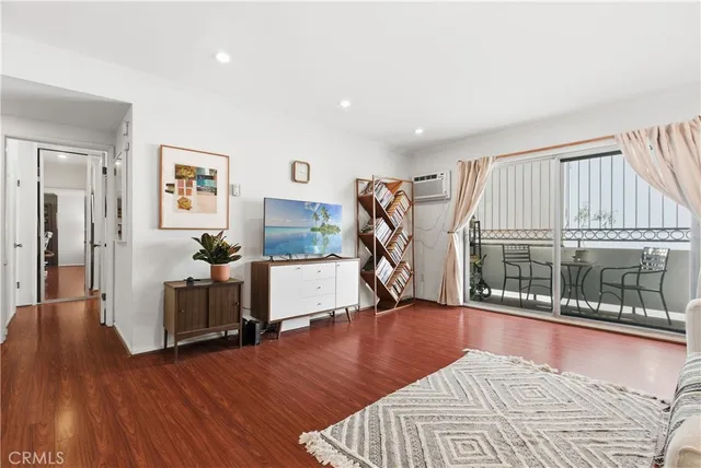 a view of a livingroom with furniture hardwood floor and a flat screen tv
