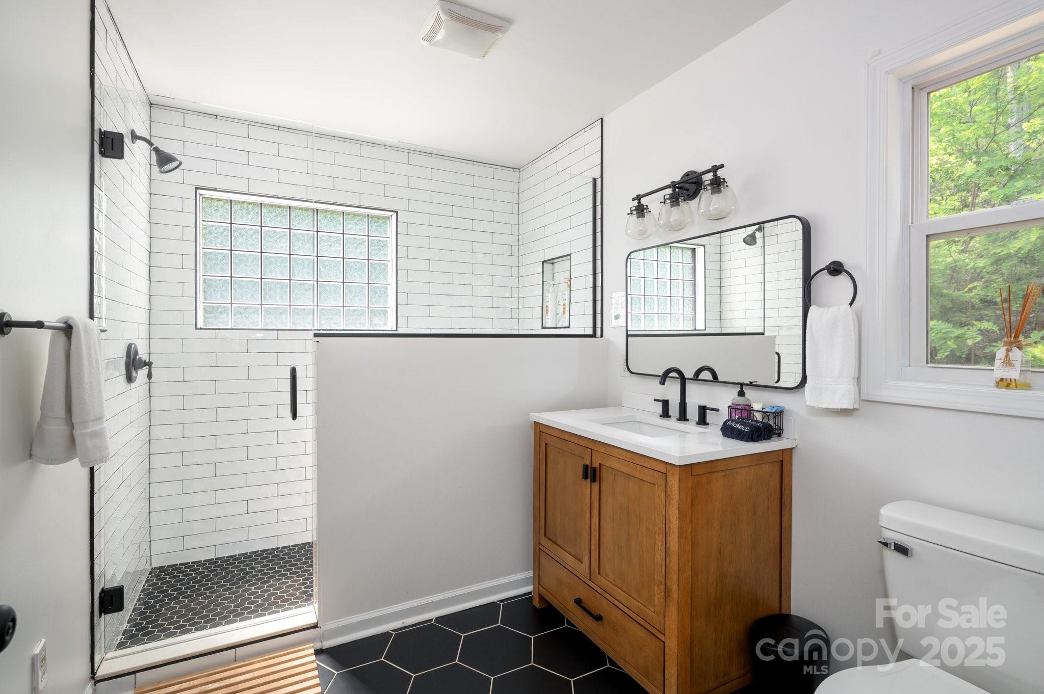 25 Lick Log Ridge Fairview, NC 28730 - Photo 18 of 34 a bathroom with a toilet a sink and a window