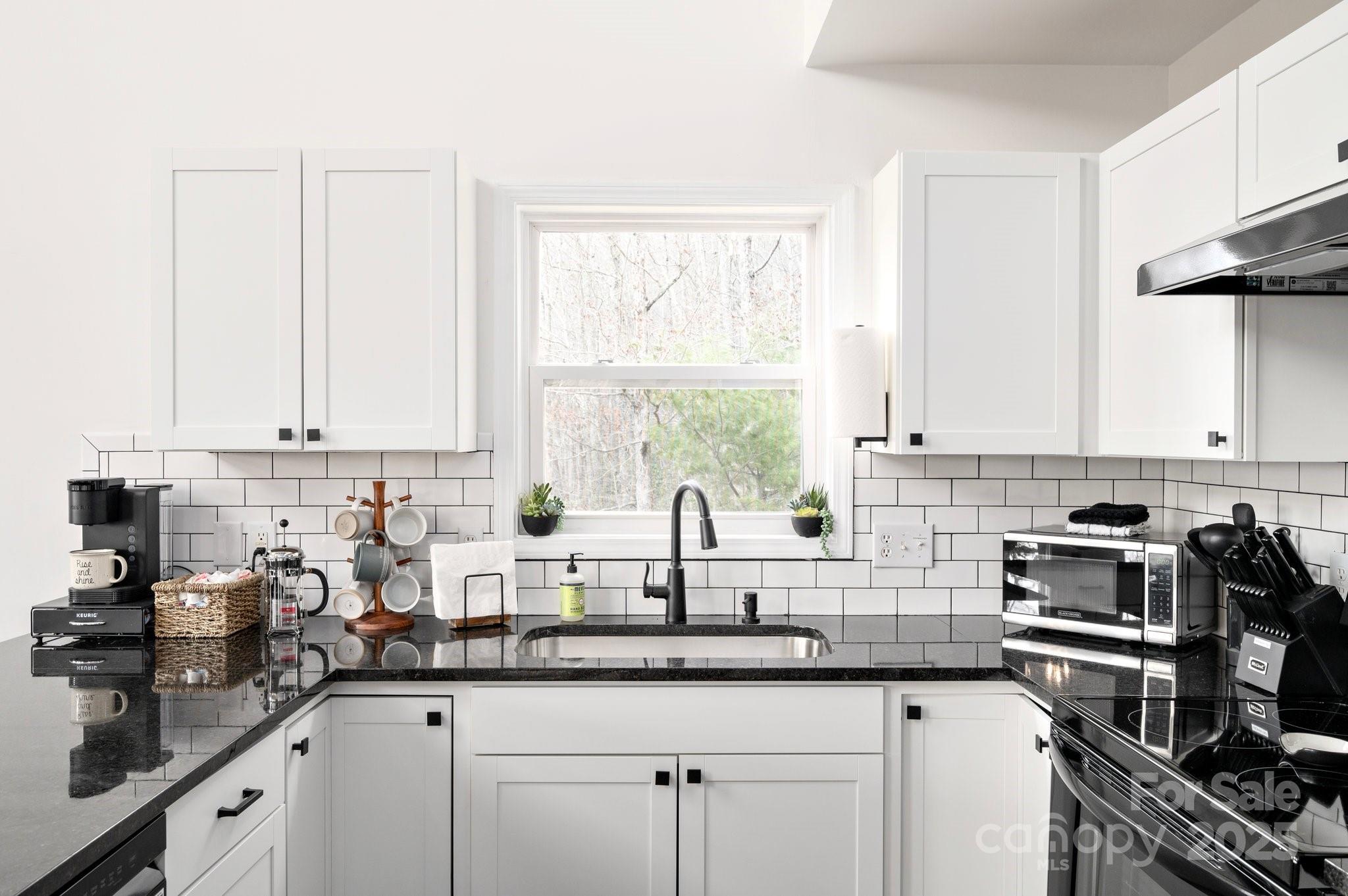 25 Lick Log Ridge Fairview, NC 28730 - Photo 10 of 34 a kitchen with stainless steel appliances a sink a window and cabinets