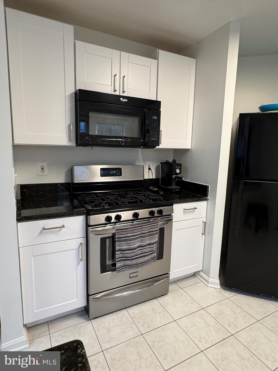 18310 Feathertree Way, Unit 101 Montgomery Village, MD 20886 - Photo 11 of 31 a kitchen with a stove and a microwave