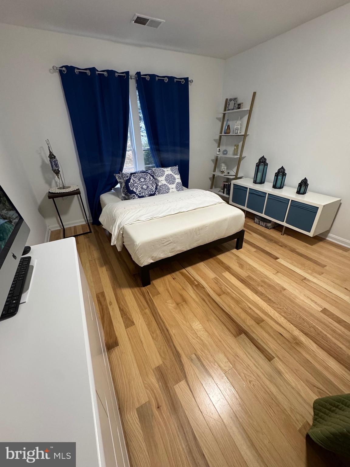 18310 Feathertree Way, Unit 101 Montgomery Village, MD 20886 - Photo 29 of 31 a bedroom with a bed and wooden floor