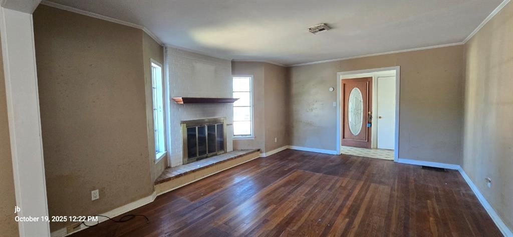 1314 South Azalea Drive Tyler, TX 75701 - Photo 5 of 27 a view of an empty room with wooden floor fireplace and a window