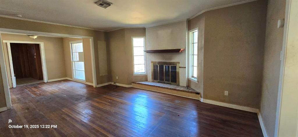 1314 South Azalea Drive Tyler, TX 75701 - Photo 6 of 27 an empty room with wooden floor and fireplace