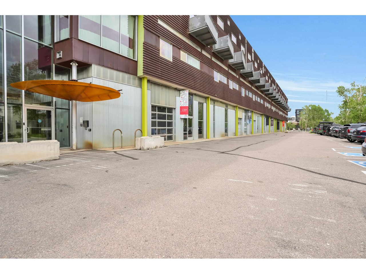 3457 Ringsby Court, Unit 327 Denver, CO 80216 - Photo 26 of 29 a view of a building with a table and a under a umbrella
