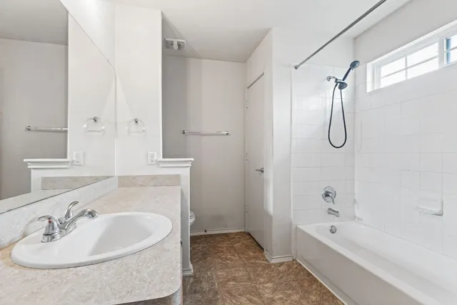 a bathroom with a bathtub shower sink and mirror