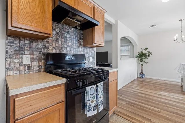 a kitchen with granite countertop a stove and a wooden floor