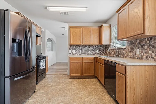 a kitchen with stainless steel appliances granite countertop a refrigerator sink and cabinets