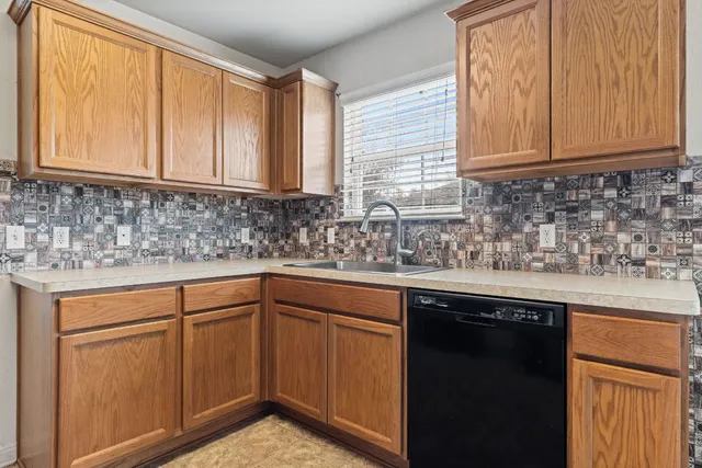 a kitchen with stainless steel appliances granite countertop cabinets sink and window