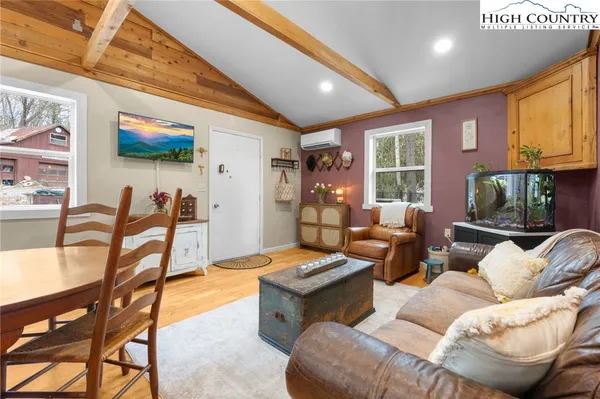 a living room with furniture a flat screen tv and a floor to ceiling window