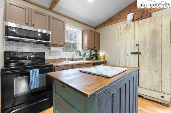 a kitchen with kitchen island granite countertop a sink stove and cabinets