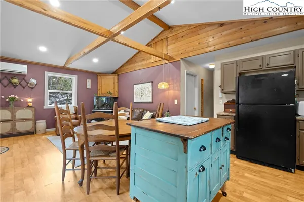 a kitchen with stainless steel appliances granite countertop a table chairs and a refrigerator