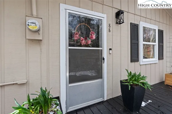 a vase of flowers sitting on a table in front of a door