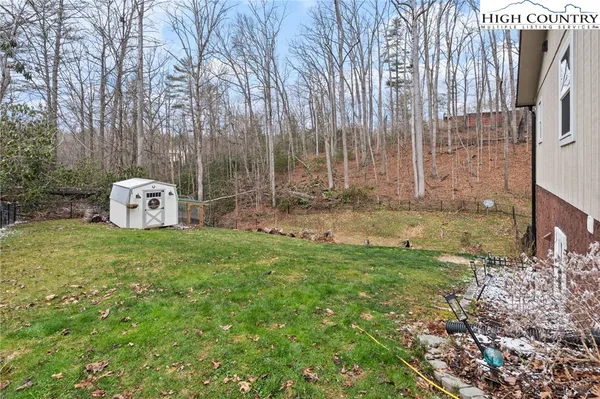 a view of a big house with a big yard and large trees