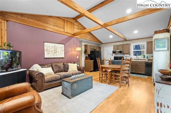a living room with furniture kitchen view and a flat screen tv