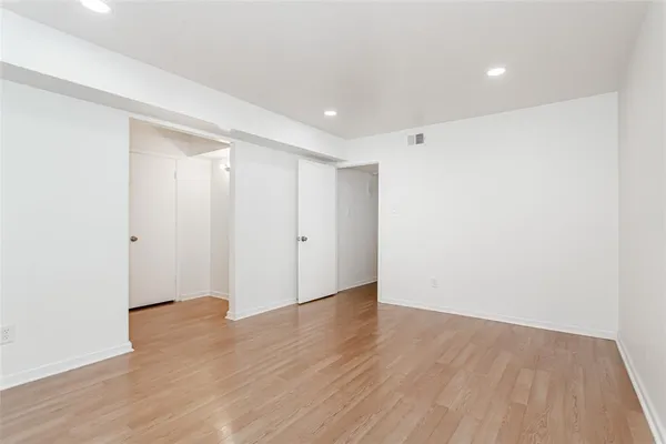 a view of an empty room with wooden floor