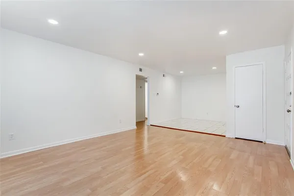 a view of an empty room with wooden floor
