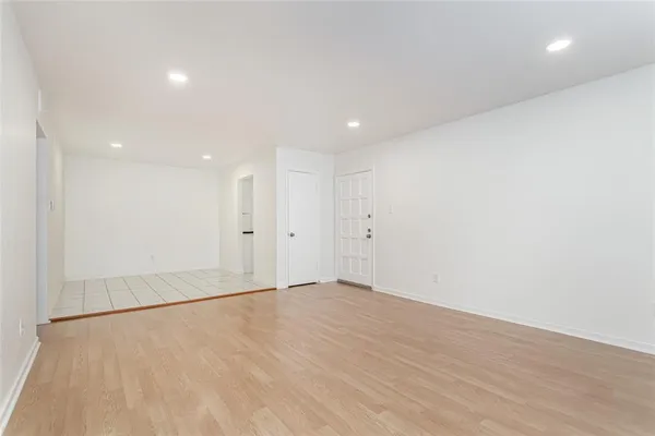 an empty room with wooden floor and white walls