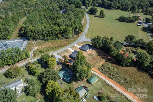 an aerial view of a house with a yard and lake view