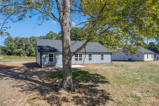 a front view of a house with yard and tree