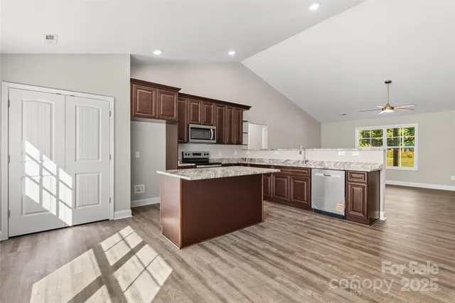 a large kitchen with stainless steel appliances granite countertop a large counter top and a stove