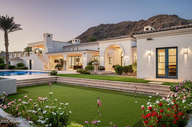 a view of swimming pool with a yard and palm trees