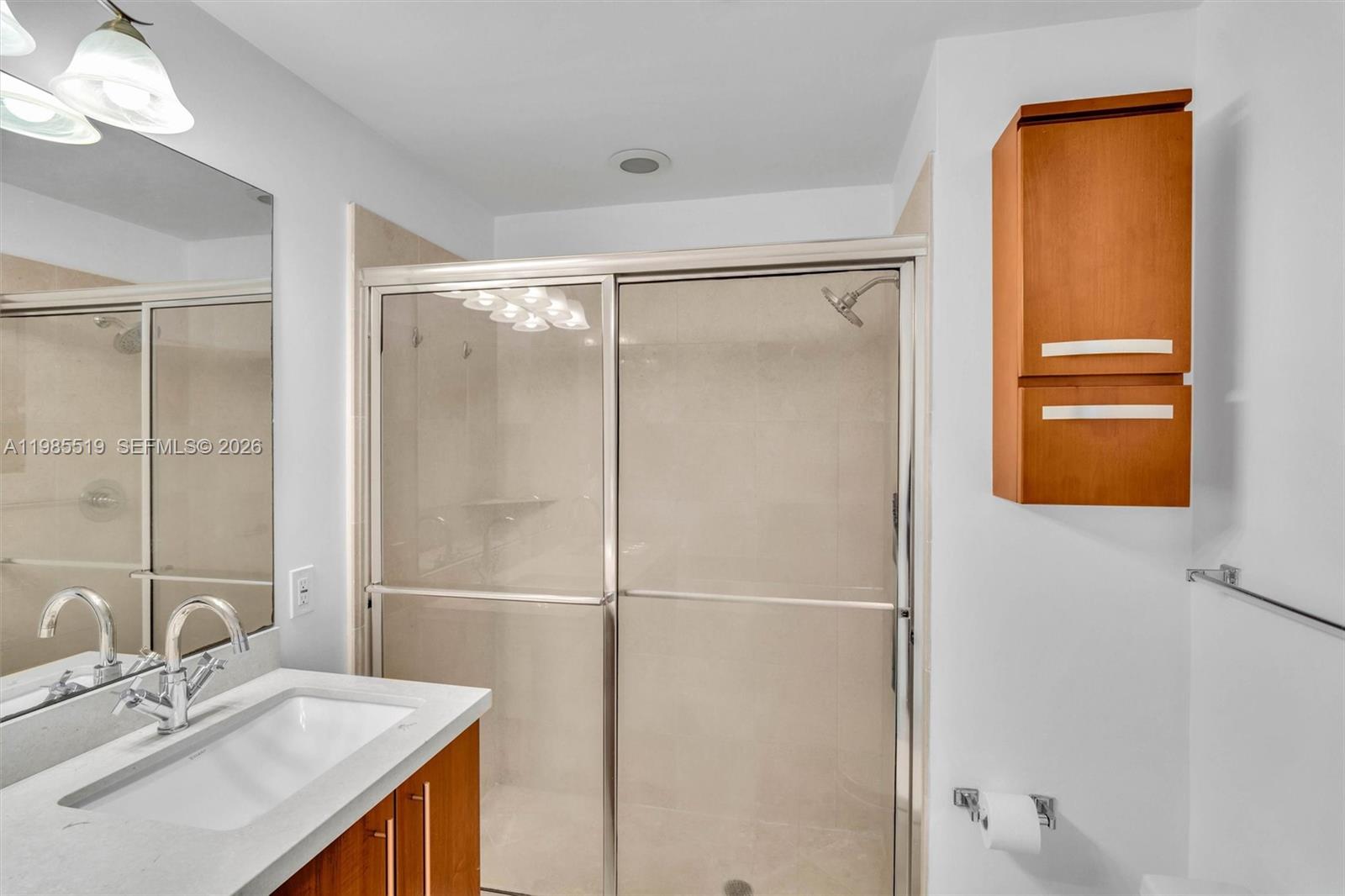 79 Southwest 12th Street, Unit 1210 Miami, FL 33130 - Photo 15 of 37 a bathroom with a shower sink vanity and mirror