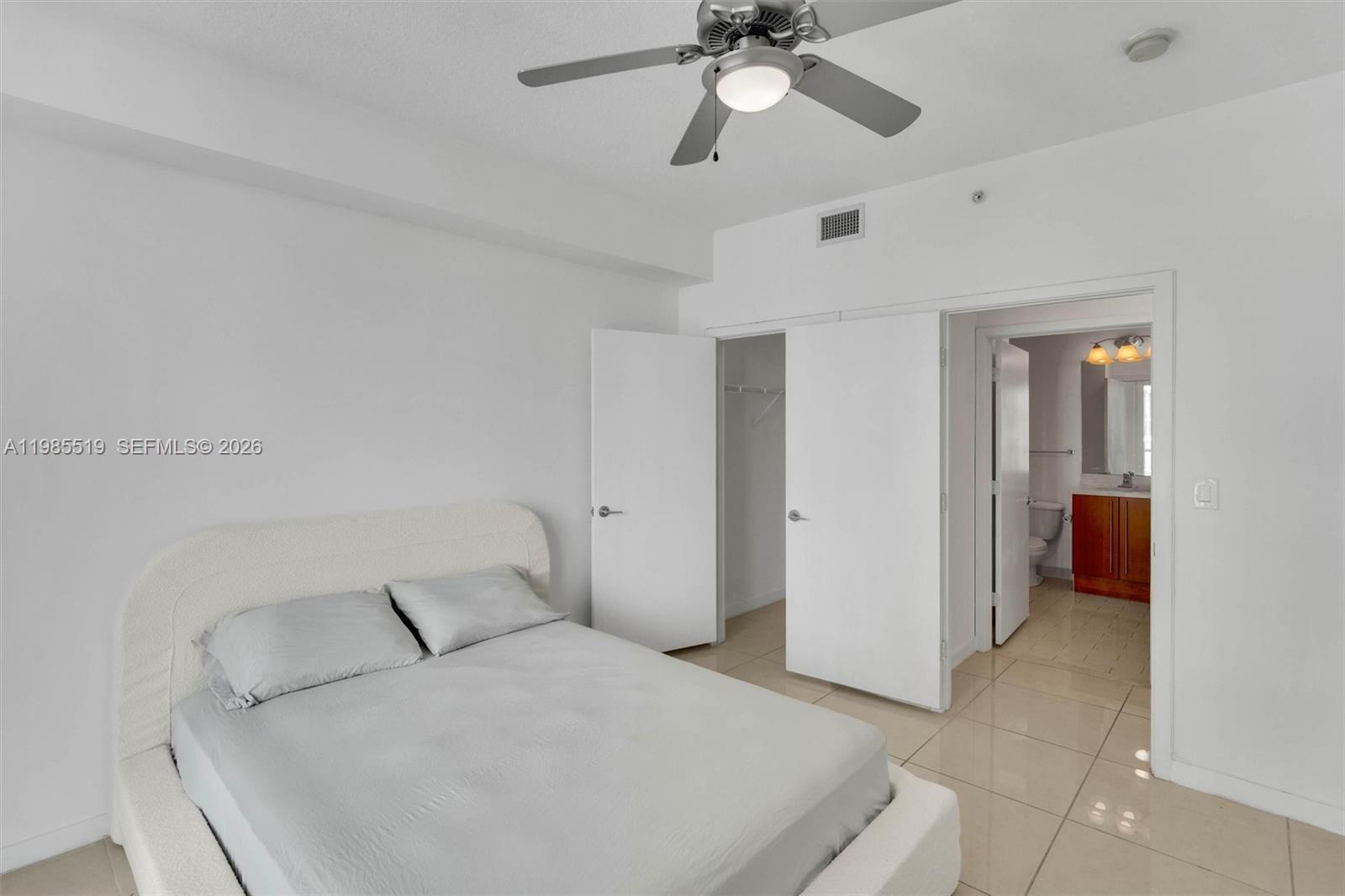 79 Southwest 12th Street, Unit 1210 Miami, FL 33130 - Photo 17 of 37 a bedroom with a bed and a chandelier