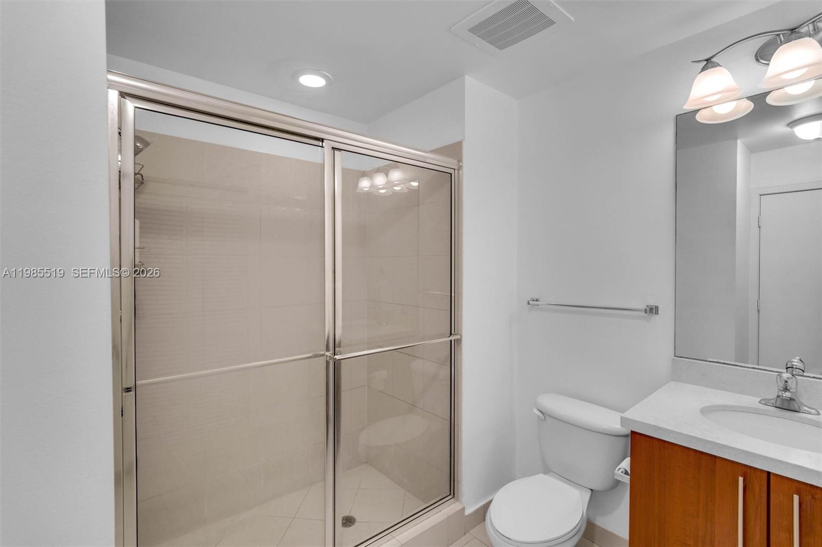 79 Southwest 12th Street, Unit 1210 Miami, FL 33130 - Photo 19 of 37 a bathroom with a granite countertop sink toilet and shower