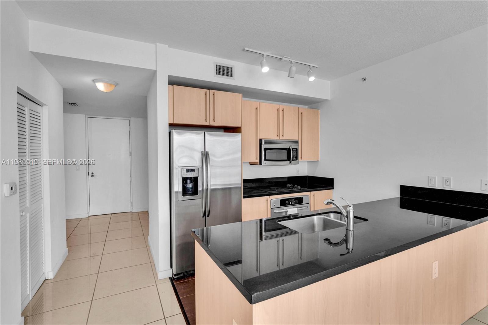79 Southwest 12th Street, Unit 1210 Miami, FL 33130 - Photo 4 of 37 a kitchen with stainless steel appliances granite countertop a sink a stove and refrigerator