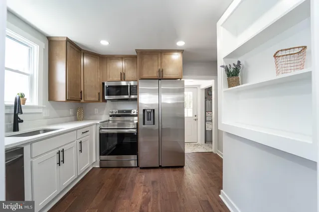 a kitchen with stainless steel appliances a refrigerator sink and microwave